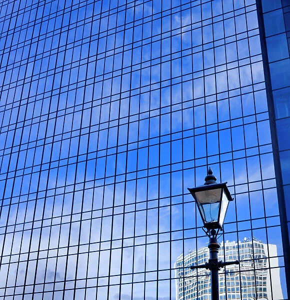 Blue sky reflected in glass tower block DP069226