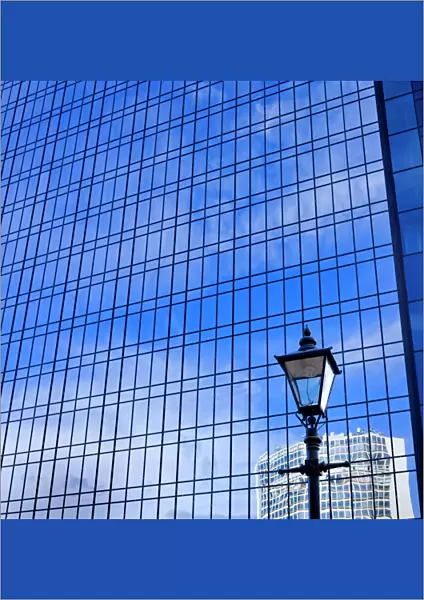 Blue sky reflected in glass tower block DP069226