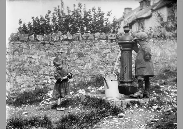 Two children collecting water at a water pump MCF01_02_0182