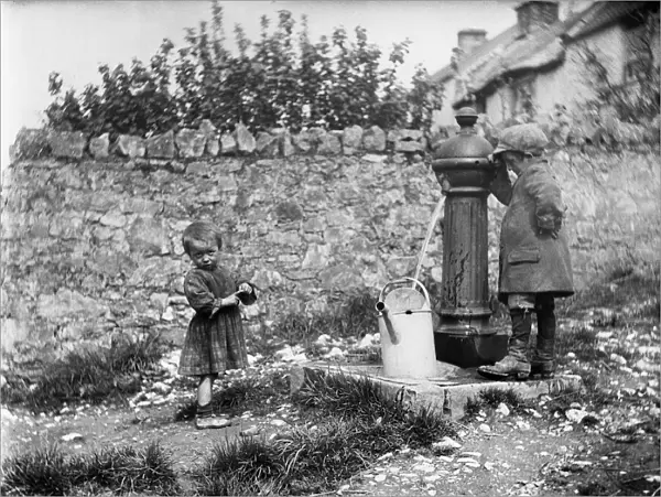 Two children collecting water at a water pump MCF01_02_0182