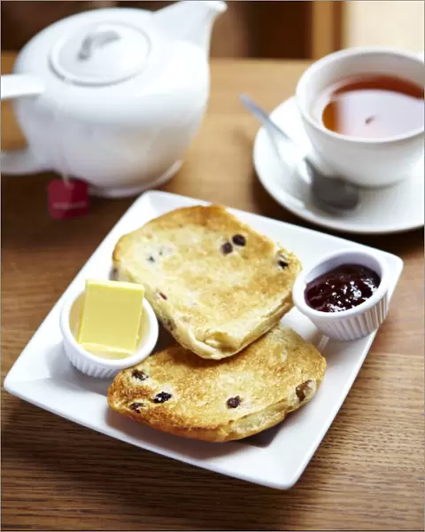 Teacake with butter and jam and a pot of tea N100359