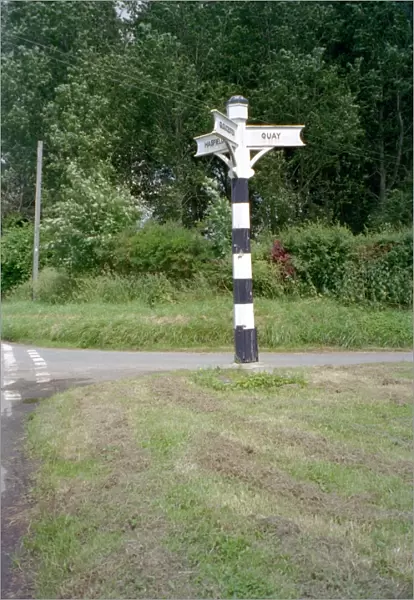 Signpost. Tapered hexagonal wooden signpost having 3 arms with lettering