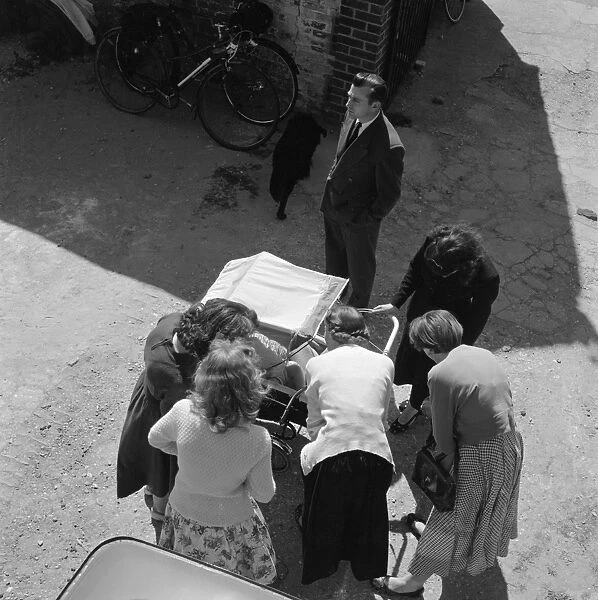 A new baby a089549. Thaxted, Essex. Looking down at a group of women cooing