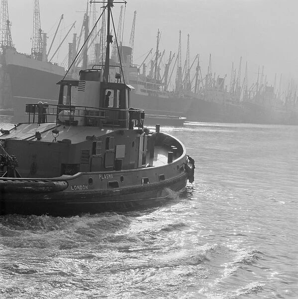 Tug boat AA064985. LONDON DOCKS. The tug Plasma in the foreground departing