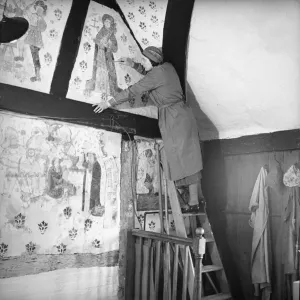 A conservator restores a medieval wall painting in The Commandery, Worcester