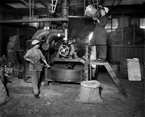 Two women filling Sirocco roaster with coffee beans BL24300_001